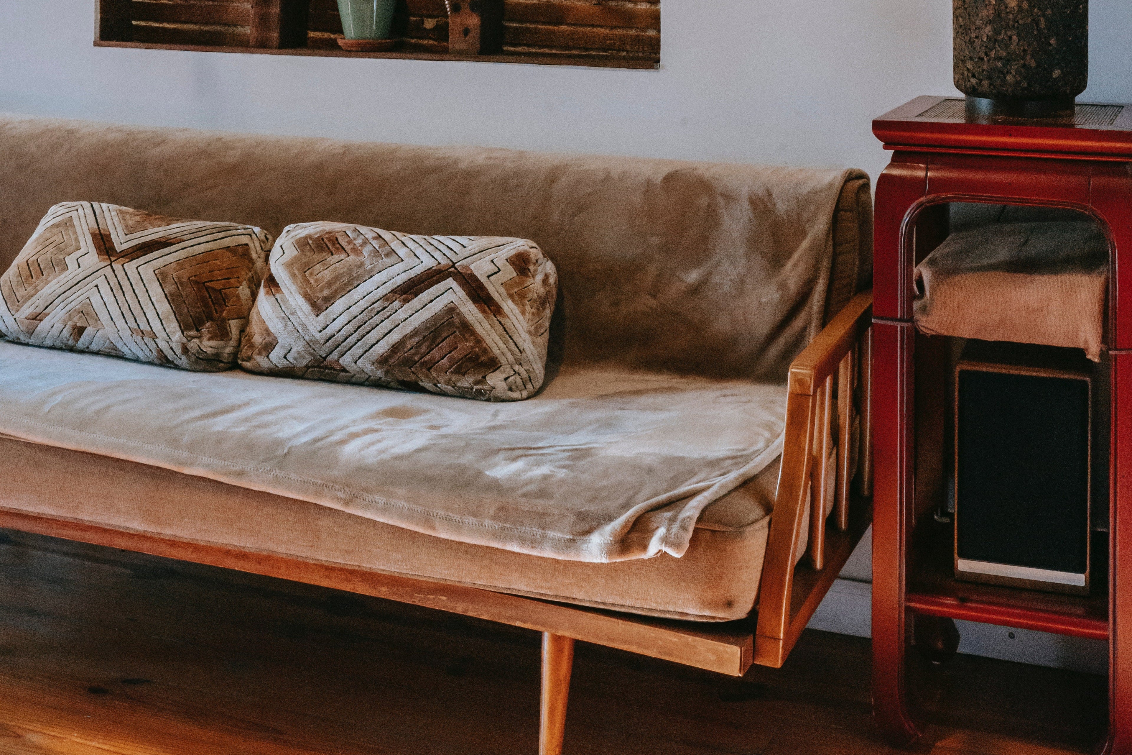 Living room with a brown sofa, wooden side table, and wall art.